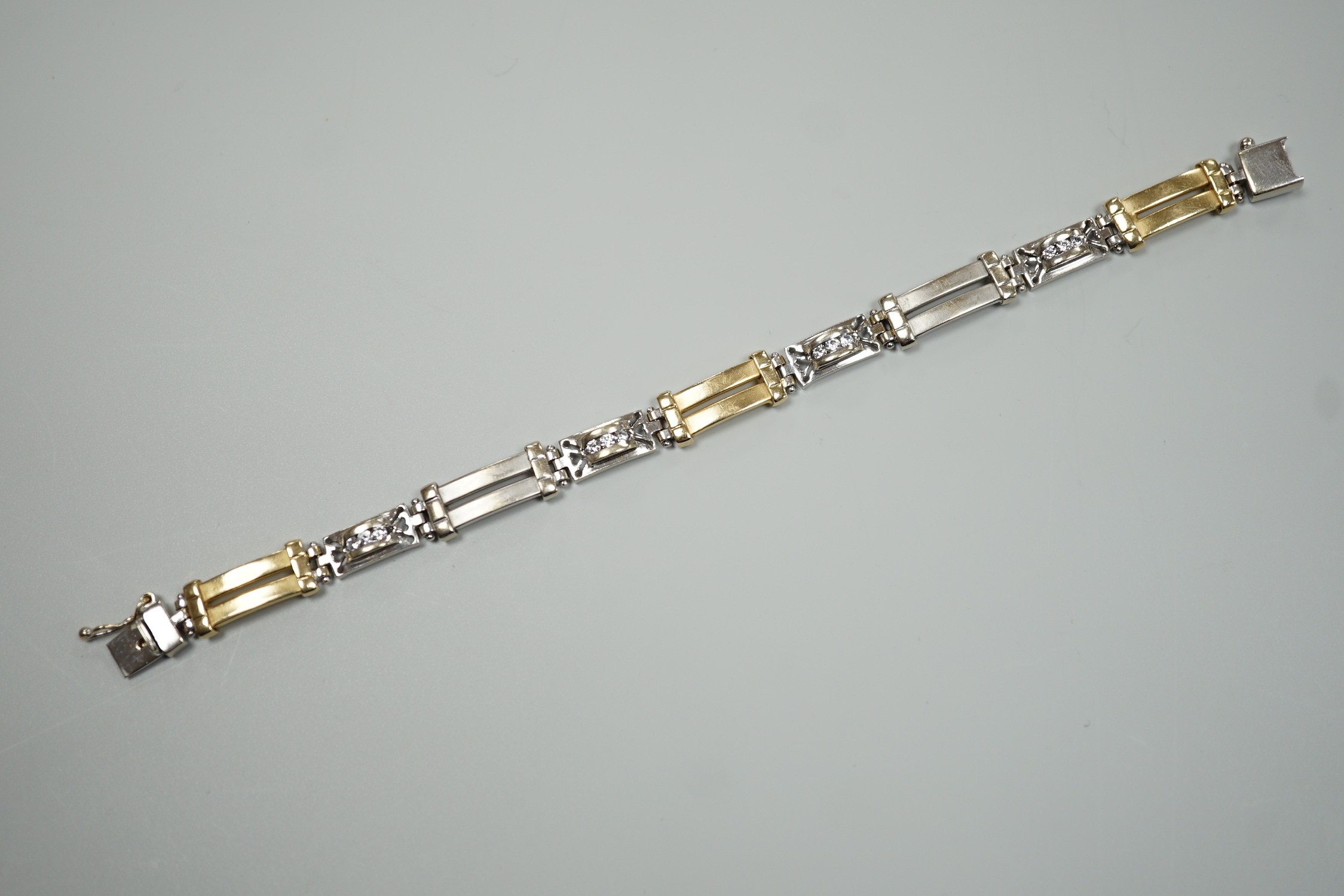 A modern two colour 585 and twelve stone diamond set bracelet, 17.75cm, gross weight 19.2 grams.